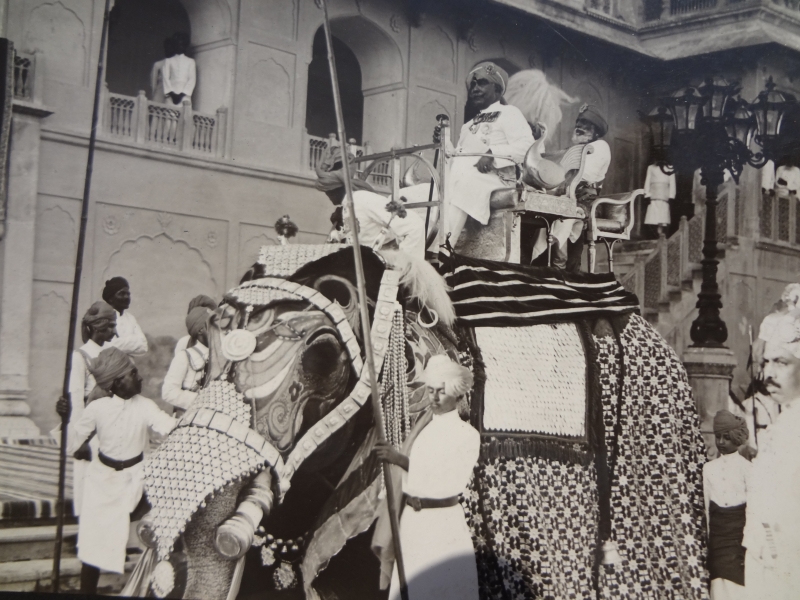 الراجا الكولونيل بوبال سينغجي (Raja Colonel Bhupal Singhji)، برفقة صاحب السمو المهراجا جانجا سينغجي (Maharaja Ganga Singhji) حاكم بيكانير، وهما يمتطيان فيلًا. بمنطقة ماهاجان